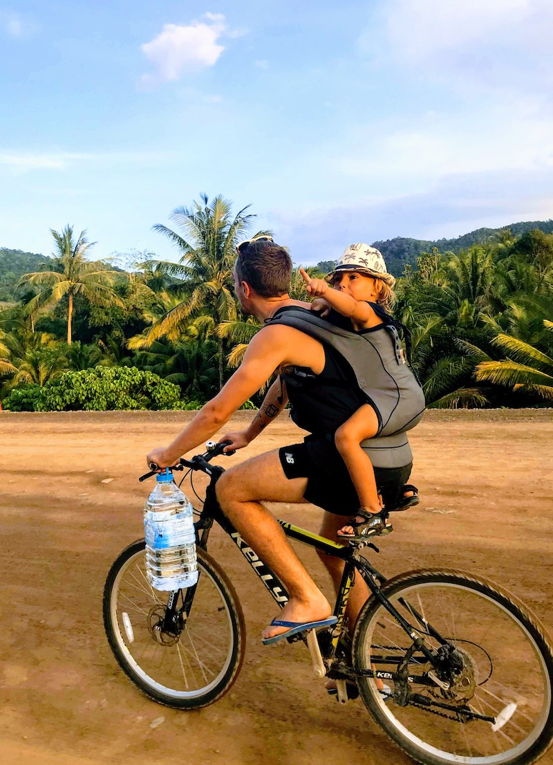 Biking on Koh Lanta, with a kid on the bag