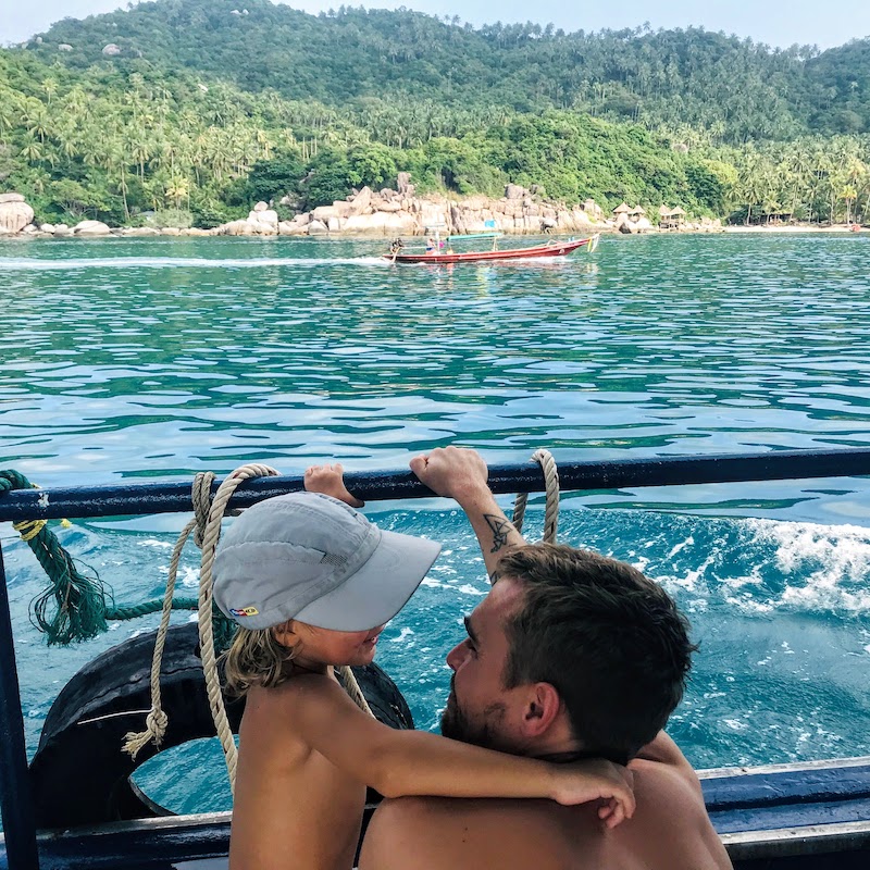 Dad and son on the boat, longtail boat and Koh Tao in the background